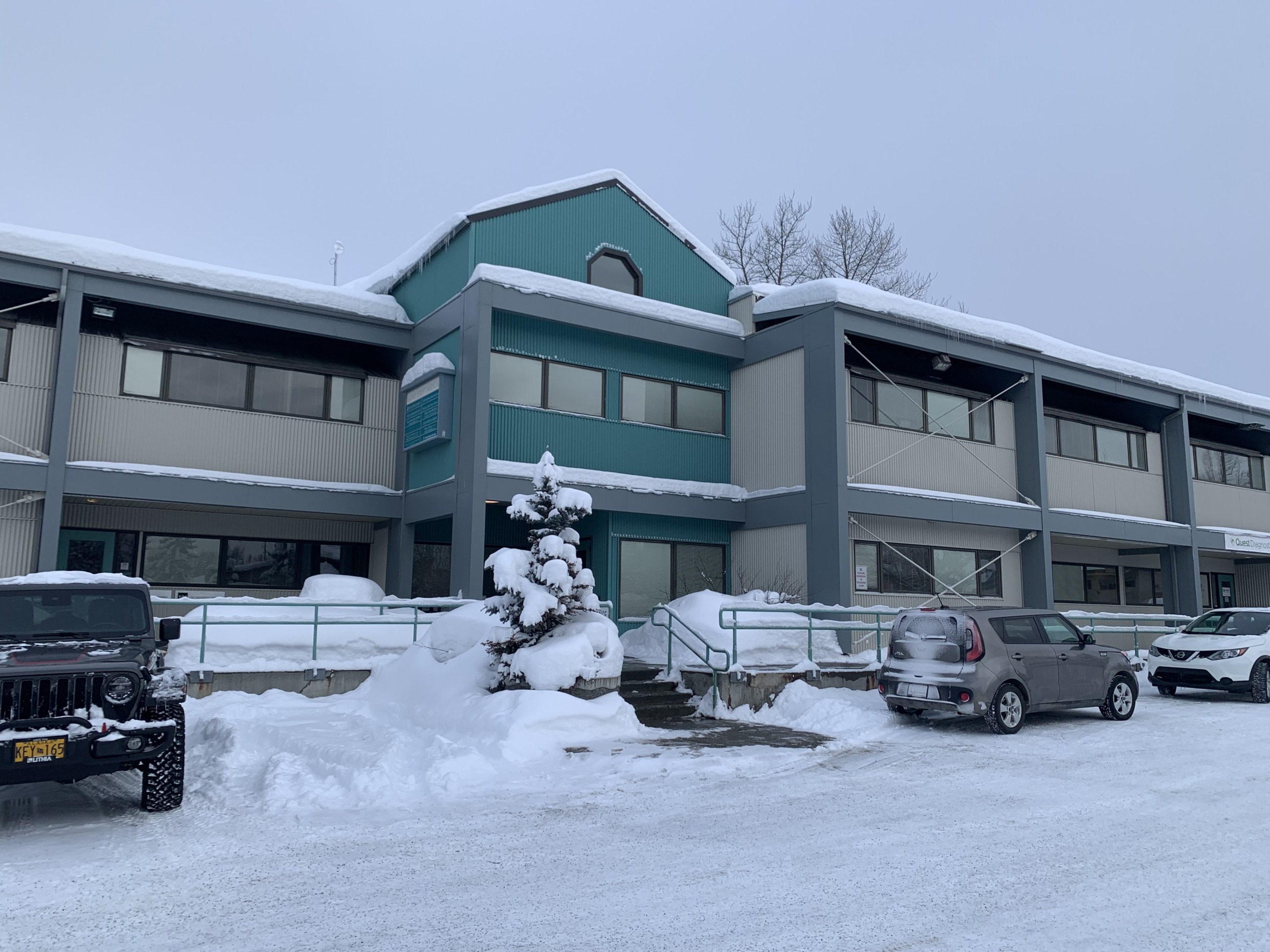 photo of green and beige office building with metal siding